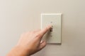 Hand turning wall light switch off. Royalty Free Stock Photo