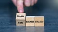 Hand turns cube and changes the expression \'big business strategy\' to \'small business strategy Royalty Free Stock Photo