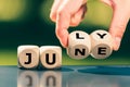 Hand turns cubes and changes the word `june` to `july` Royalty Free Stock Photo