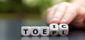 Hand turns dice and changes the acronym `toefl` to `toeic`, or vice versa`.