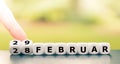 Hand turns dice and changes the date from `February 28` to `February 29` 28 and 29 Februar in German.