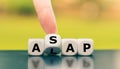 Hand turns a dice and changes the expression `ALAP` as late as possible to `ASAP` as soon as possible, or vice versa. Royalty Free Stock Photo