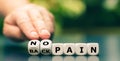 Hand turns dice and changes the expression `back pain` to `no pain`. Royalty Free Stock Photo