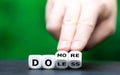 Hand turns dice and changes the expression `do less` to `do more`. Royalty Free Stock Photo