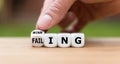 Hand turns a dice and changes the expression `failing` to `winning` Royalty Free Stock Photo