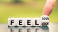 Hand turns a dice and changes the expression `feel sick` to `feel good. Royalty Free Stock Photo