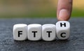 Hand turns dice and changes the expression Fiber to the curb FTTC to Fiber to the home FTTH. Royalty Free Stock Photo