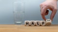 Hand turns a dice and changes the expression `half empty` to `half full`. Royalty Free Stock Photo