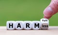 Hand turns a dice and changes the expression `harmfull` to `harmless`. Royalty Free Stock Photo