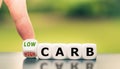 Hand turns a dice and changes the expression from `high carb` to `low carb`. Royalty Free Stock Photo