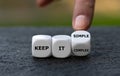 Hand turns dice and changes the expression `keep it complex` to `keep it simple`. Royalty Free Stock Photo
