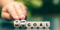 Hand turns dice and changes the expression `my goal` to `our goal`.