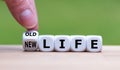 Hand turns a dice and changes the expression `old life` to `new life` Royalty Free Stock Photo