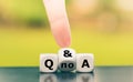 Hand turns a dice and changes the expression `Questions no Answers` to `Questions and Answers`. Royalty Free Stock Photo