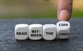 Hand turns dice and changes the expression `read between the lines` to `read between the lies`. Royalty Free Stock Photo
