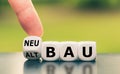 Hand turns a dice and changes the German word `Altbau` `old construction` in English to `Neubau` `new construction` in Royalty Free Stock Photo