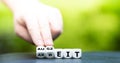 Hand turns dice and changes the German word `Arbeit` work to `Auszeit` time off.