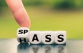 Hand turns a dice and changes the German word `Hass` `hate` in English to `Spass` `fun` in English, or vice versa.