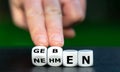 Hand turns dice and changes the German word `nehmen` take to `geben` give. Royalty Free Stock Photo