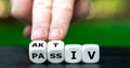 Hand turns dice and changes the German word `passiv` passive to `aktiv` active.