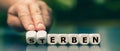 Hand turns dice and changes the German word `sterben` `die` to `erben` `inherit`. Royalty Free Stock Photo