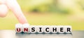 Hand turns dice and changes the German word `unsicher` `unsafe` to `sicher` `safe`.