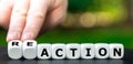 Hand turns dice and changes the word action to reaction. Royalty Free Stock Photo