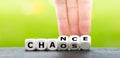 Hand turns dice and changes the word chaos to chance Royalty Free Stock Photo