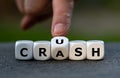 Hand turns dice and changes the word crash to crush.