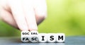 Hand turns dice and changes the word fascism to socialism Royalty Free Stock Photo