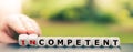 Hand turns dice and changes the word `incompetent` to `competent`. Royalty Free Stock Photo