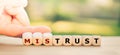 Hand turns dice and changes the word `mistrust` to `trust`.