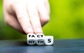 Hand turns dice and changes the word myths to facts