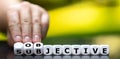 Hand turns dice and changes the word `subjective` to `objective`. Royalty Free Stock Photo