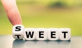 Hand turns a dice and changes the word `sweet` to `tweet. Royalty Free Stock Photo