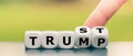 Hand turns dice and changes the word `Trump` to `Trust`.