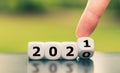 Hand turns a dice and changes the year `2020` to `2021`.