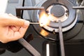 Hand turns on the gas burner on the gas stove Royalty Free Stock Photo