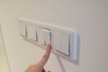 The hand turns off and on the light. Energy saving. Light switch. Finger presses the button Royalty Free Stock Photo
