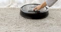 Hand turns on the round robot vacuum cleaner