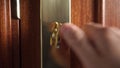 The hand turns and unlocks the bronze gold door bolt lock and opens the door