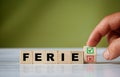 hand turns the wooden cube and changes the polish word FERIE english = holidays with green positive tick check box and red rejec