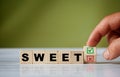 hand turns the wooden cube and changes the word SWEET with green positive tick check box and red reject X check box Royalty Free Stock Photo