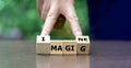 Hand turns wooden cubes and changes the word magic to imagine