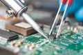 Hand with tweezers holding the chip, soldering iron solder it in place. Computer repair. Macrophotography. Copy space.