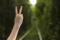 Hand with two fingers up in the peace or sign for symbol of peace or victory on natural background. woman shows number two with Royalty Free Stock Photo