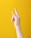 Hand with two fingers up shows goat gesture on yellow background. symbol of heavy metal and rock music Royalty Free Stock Photo