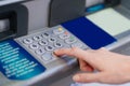 the hand types the pin code on the ATM keyboard.