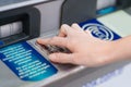 the hand types the pin code on the ATM keyboard.