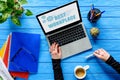 hand typing on laptop keyboard on blue wooden table with stationery and coffee, Best Royalty Free Stock Photo